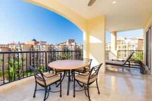 Un comedor con mesa y sillas en un balcón. en 2BD Standard Suite Villa del Palmar Flamingos, en Nuevo Vallarta 