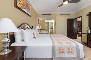 Un dormitorio con una gran cama blanca con una lámpara. en 2BD Standard Suite Villa del Palmar Flamingos, en Nuevo Vallarta 