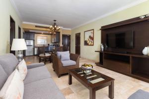 Una sala de estar con un sofá y un televisor. en 2BD Standard Suite Villa del Palmar Flamingos, en Nuevo Vallarta 