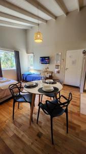 a living room with a table and chairs and a bed at Cabaña monoambiente en Bariloche 3 pax in San Carlos de Bariloche