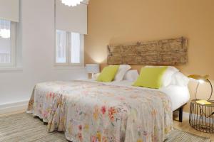 sypialnia z łóżkiem z zielonymi poduszkami w obiekcie Ambrosse by FeelFree Rentals w mieście San Sebastián