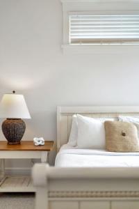 a bedroom with a bed and a table with a lamp at The Willow - 20 Butternut in Cherry Valley