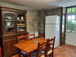eine Küche mit Holztisch und Kühlschrank in der Unterkunft Casa dos Limões - Paredes de Coura in Formariz