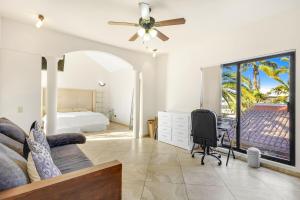 une chambre avec un lit, un bureau et un ventilateur de plafond dans l'établissement La Posada Alberca privada y playa cercana, à La Paz 40 autres photos