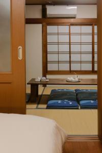 Una habitación con una cama y una mesa con almohadas azules. en 貸切 一戸建て古民家 3部屋 静か, en Osaka