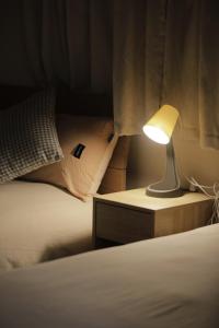 una lámpara en una mesita de noche junto a una cama en 貸切 一戸建て古民家 3部屋 静か, en Osaka
