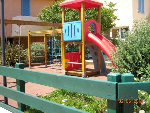 um parque infantil com escorrega num parque em Residence Le Nereidi em La Maddalena