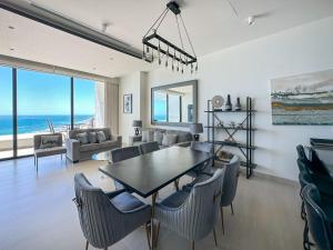 a dining room and living room with a table and chairs at 2BR Sandy Beach Beachfront Getaway in Puerto Peñasco