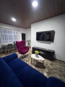 ein Wohnzimmer mit einem blauen Sofa und einem Fernseher in der Unterkunft acogedor y excelente ubicación in Bogotá