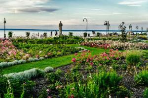 a garden with flowers and a man in the background at Apartment in Siofok - Balaton 54329 in Siófok