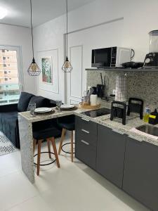 een keuken met een aanrecht en een tafel met stoelen bij Pedra do Sal Privilege in Salvador