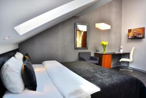 a bedroom with a bed and a desk and a mirror at Ametyst Hotel Praha in Prague +37 photos