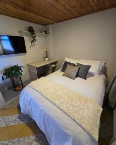 a bedroom with a large white bed and a desk at Hotel Boutique Santa María in Filandia +2 photos