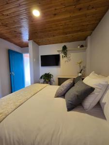 a bedroom with a large white bed with a blue door at Hotel Boutique Santa María in Filandia