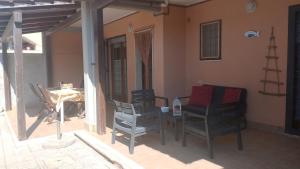 a patio with a table and chairs on a porch at La DUNA in Torvaianica