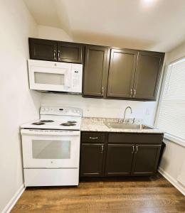 ピッツバーグにあるCozy 1BR Retreat - Private - Near Cityのキッチン(黒いキャビネット、白い電化製品付)