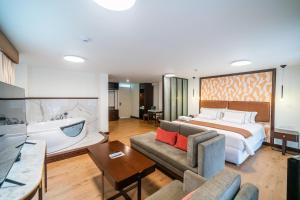 a hotel room with a bed and a couch at Hotel Taypikala Machupicchu in Machu Picchu