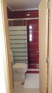 a bathroom with a toilet and a red door at Residencial Condado in Faro +38 photos