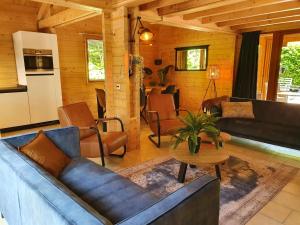 a living room with couches and a table at Villa in Forest with Private Sauna in Markelo