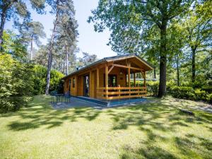 Una cabaña en el bosque con un gran patio. en Lodge in Markelo with Sauna and Pool Nearby, en Markelo