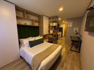 1 dormitorio con 1 cama con cabecero verde y escritorio en Modern Loft in 85st near Andino, en Bogotá