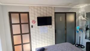 a room with a bed and a tv on a wall at Midway lodge in Standerton