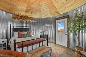 una camera da letto con un letto e un soffitto in legno di Southwest Silo Stay- 1 Bedroom Near Zion & Bryce a Cane Beds