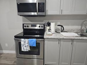 レジャイナにあるSerene Private Basement Suite in Reginaのコンロと電子レンジ付きのキッチン +10枚の写真