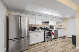 a kitchen with white cabinets and stainless steel appliances at Near Beaches, Downtown Melbourne, MLB Airport, FIT, and HRMC! 1 in Melbourne