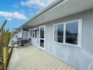 a deck with a table and chairs on a house at Cosy Chalet On A Beautiful Holiday Park In Lowestoft Ref 12080B in Lowestoft