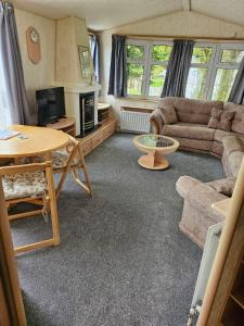 a living room with a couch and a table at Lovely Caravan At Manor Park, Nearby Hunstanton Beach In Norfolk Ref 23029T in Hunstanton