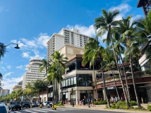 ホノルルにあるRoyal Kuhio 1711 - Spacious Studio with Stunning Ocean City Views in the Heart of Waikiki!のヤシの木と高い建物のある街道