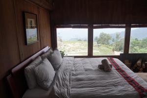 a bedroom with a bed with a teddy bear on it at The Vu's Ha Giang in Lan Hung