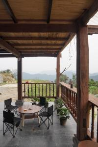 a wooden pergola with a table and chairs on a patio at The Vu's Ha Giang in Lan Hung