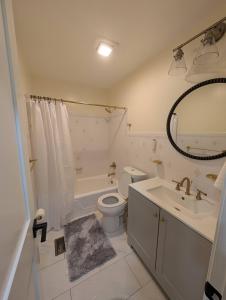ein Badezimmer mit Toilette, Badewanne und Waschbecken in der Unterkunft Beautiful 3b2ba home near MGM and National Harbor in Fort Washington