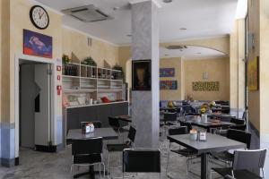 ein Restaurant mit Tischen und Stühlen und einer Uhr an der Wand in der Unterkunft Hotel Ferrari in Chiavari