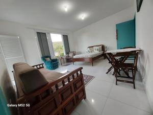 a living room with a bed and a desk at Recanto Inglês, Prainha e Martim de Sá in Caraguatatuba
