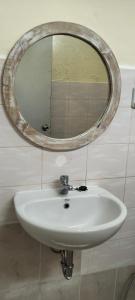 espejo sobre un lavabo blanco en el baño en Rumah Sedana, en Ubud