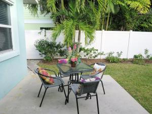a patio table with two chairs and a table with flowers at Sand Dollar Beach Side Villa in Holmes Beach