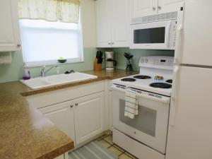 a kitchen with a white stove and a sink at Sand Dollar Beach Side Villa in Holmes Beach