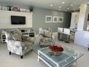 a living room with two chairs and a table at Sunset Beach 101 Beach Front Unit in Holmes Beach