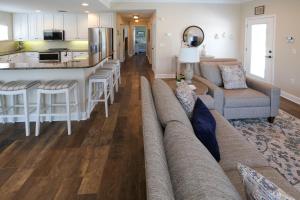 a living room with a couch and a kitchen at Hibiscus Hideaway Condo Walk To Historic Bridge St in Bradenton Beach