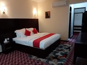 a hotel room with a bed with red and white pillows at Hunza Roof Hotel in Hunza