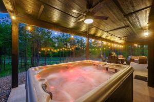 a jacuzzi tub in a backyard with a patio at The Animal Crossing -Direct ATV trail access, hot tub, and fire pit near Hochatown in Broken Bow