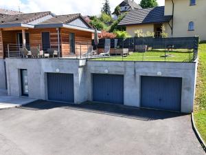a house with two garage doors in a driveway at Charmante maison à Évian avec terrasse et parking - FR-1-498-113 in Évian-les-Bains