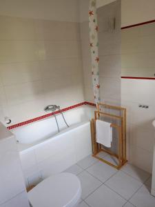 a bathroom with a tub and a toilet and a sink at Dom Wakacyjny Wojnówko in Wojnówko +8 photos