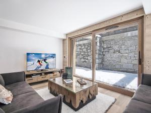 ein Wohnzimmer mit Couch und großem Fenster in der Unterkunft Appartement neuf proche des pistes avec parking - FR-1-570-67 in Praranger