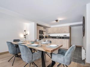 ein Esszimmer mit einem Holztisch und Stühlen in der Unterkunft Appartement neuf proche des pistes avec parking - FR-1-570-67 in Praranger