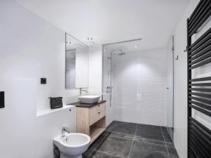 ein weißes Badezimmer mit Waschbecken und Toilette in der Unterkunft Appartement neuf proche des pistes avec parking - FR-1-570-67 in Praranger + 7 Fotos