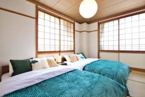 two beds in a room with two windows at okn飛騨高山201 in Takayama